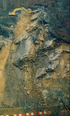 Drilling on major landslide on hillside , excavator on stable ground